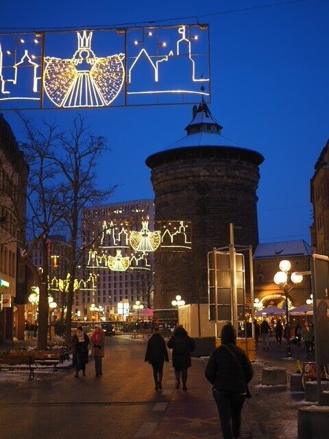 Christmas lights in the shape of the Nuremberg Christkind light up a gloomy winter street