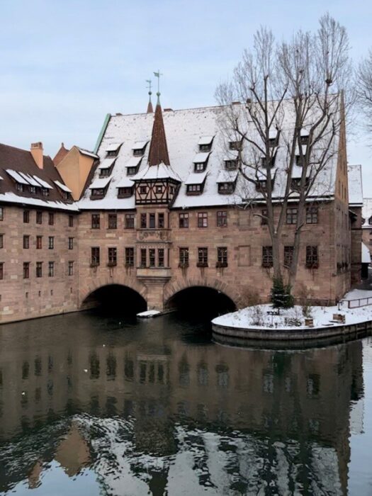 The Heilig Geist Spital sits out over the Pegnitz River in Nuremberg covered in snow.