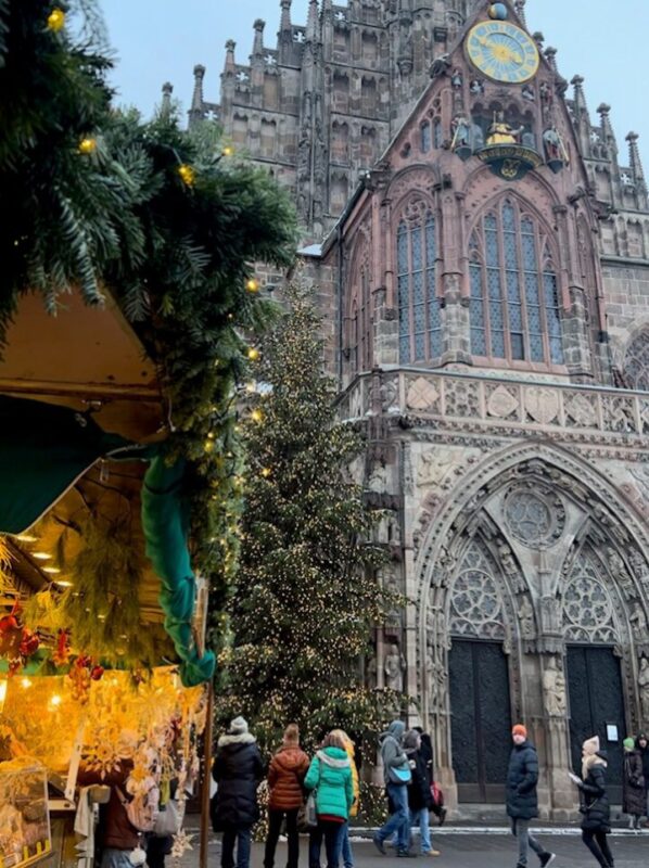 Golden light suffuses out from a Christmas market stall and in the background the Frauenkirche's gothic towers dominate the sky