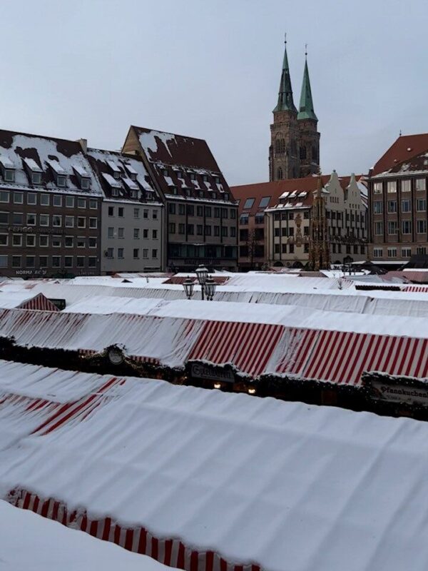 Looking out over the Christkindlesmarkt in the main square of Nuremberg, Sebalduskirche's twin spires peek over the townhouses.