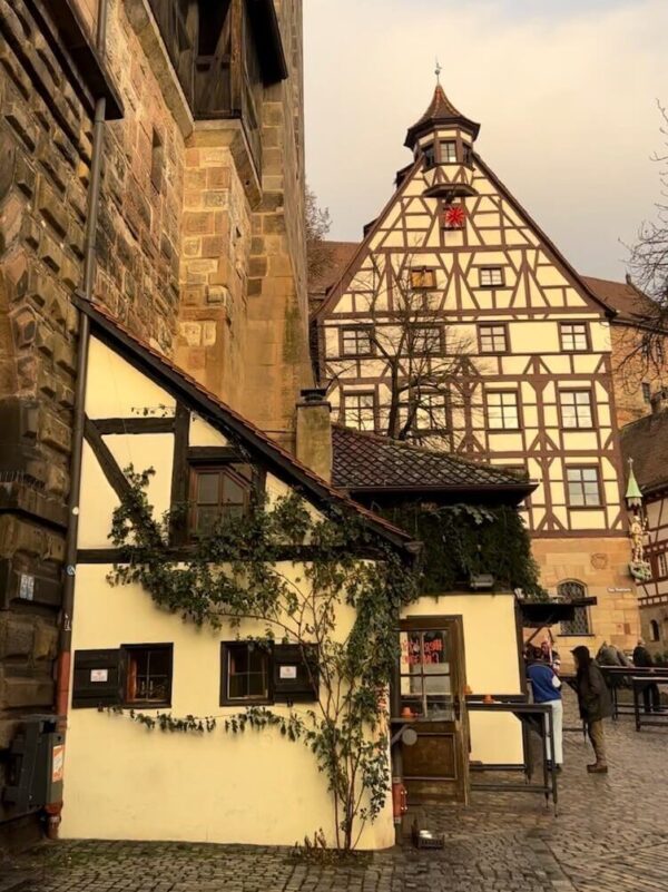Multiple half timbered houses are shown in a city square in Nuremberg