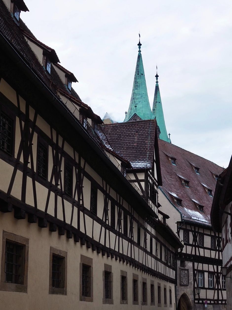 Blue-green copper spires peep over the dark roofs of medieval houses in the backstreets of Bamberg.