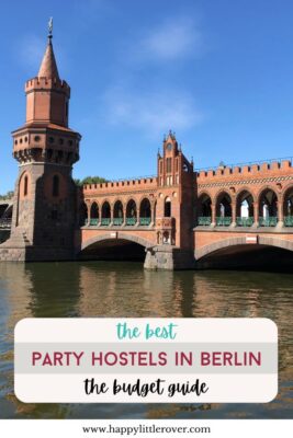A large red brick bridge with decorative turrets and towers, along with large porticos, rises above the brown Spree River under a blue sky. The text reads the best party hostels in Berlin the budget guide