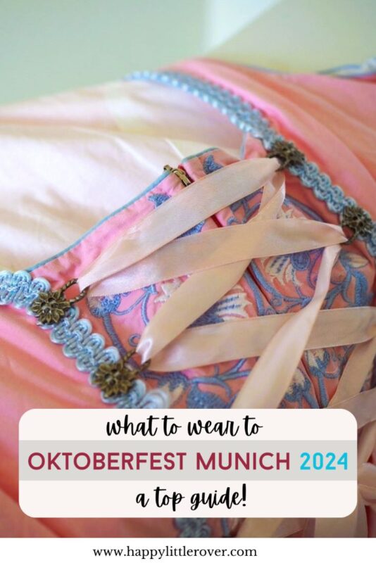 A pink, embroidered dress with ribbons laced across the bodice has print over the top of it, the text reads what to wear to Oktoberfest Munich 2024